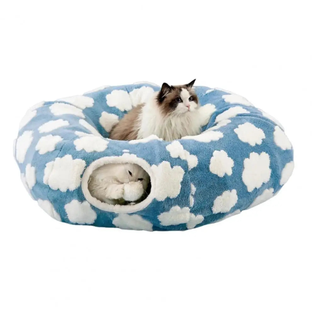 Cat lying on a blue cloud-patterned pet bed against a white background