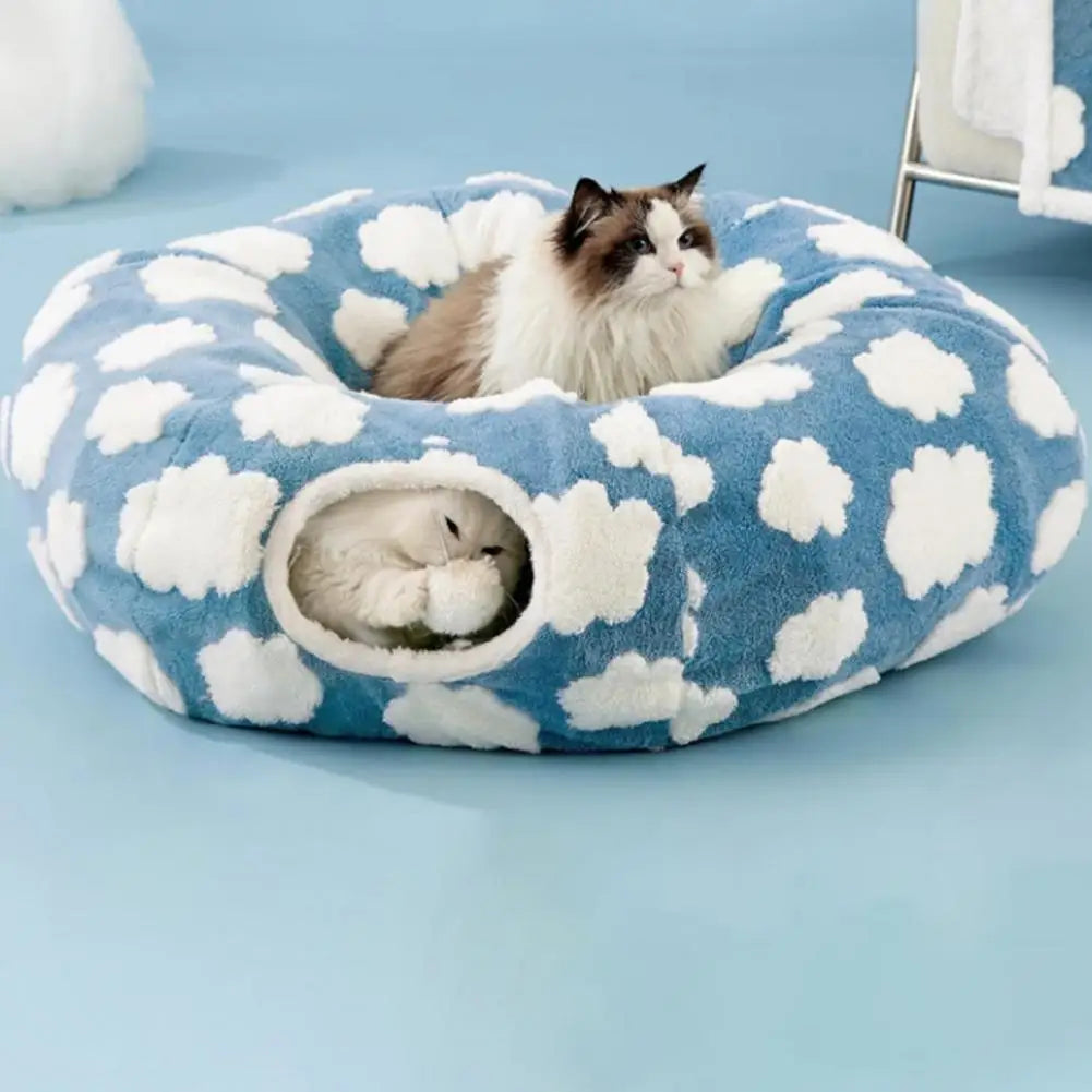 Cat lying on a blue pet bed with cloud pattern